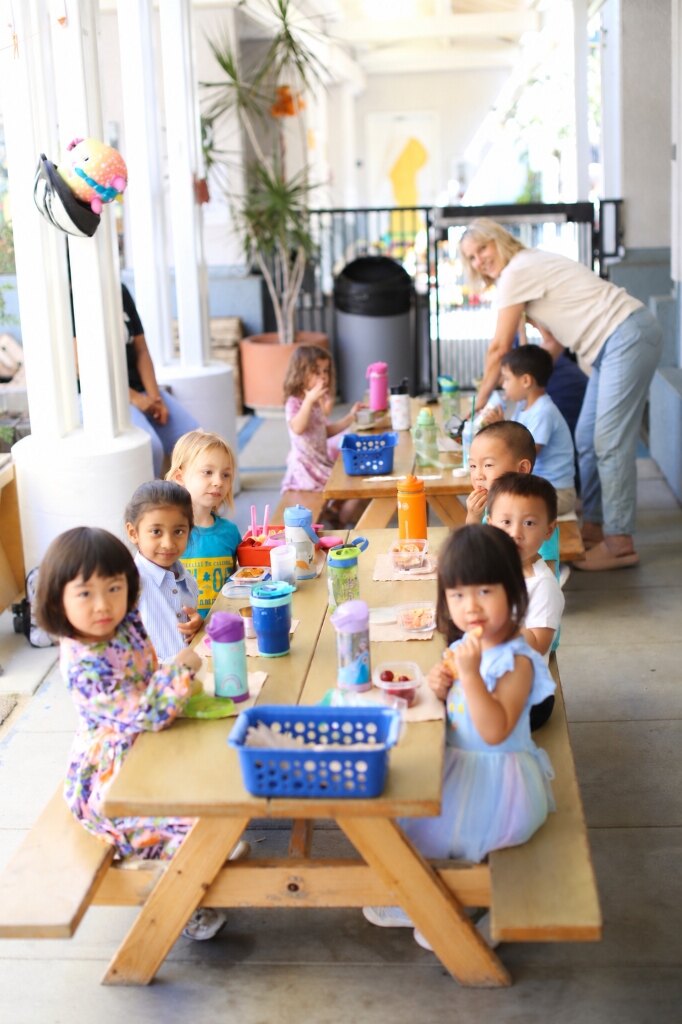 Dolphin Room children sharing snacks and lunch together at the outdoor picnic table