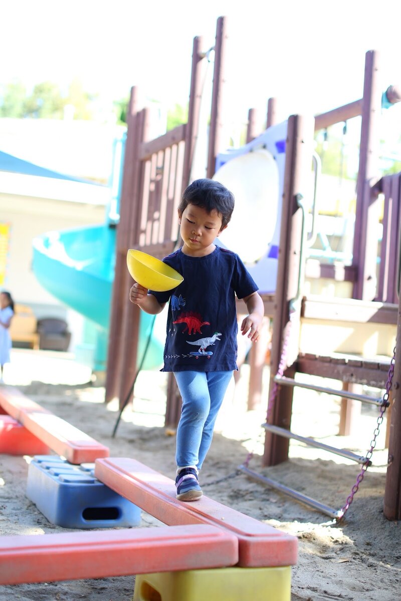 Child climbing on the outdoor play structure in the Kangaroo Room