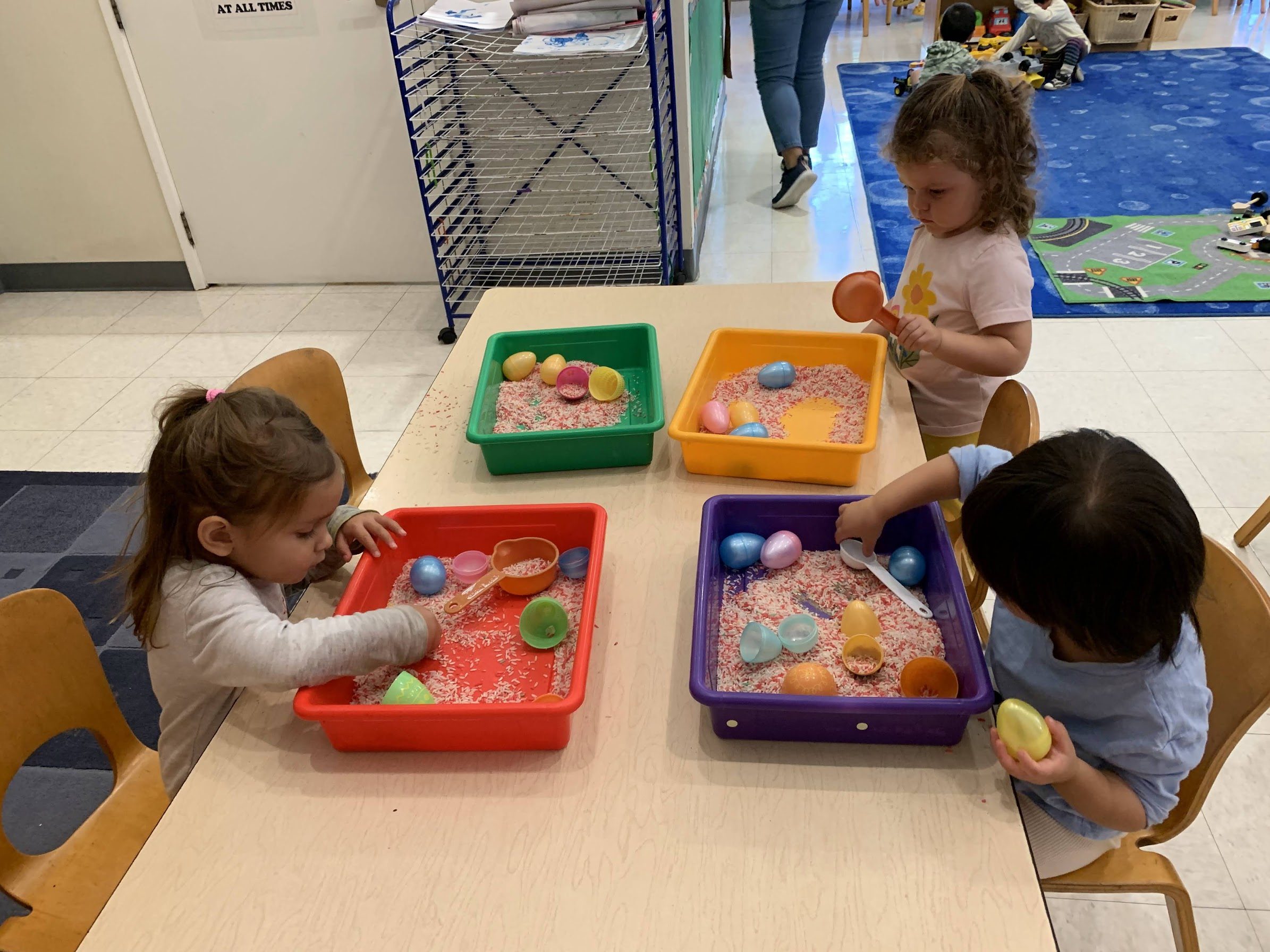 Toddlers playing with sand and eggs in the Kitten Room