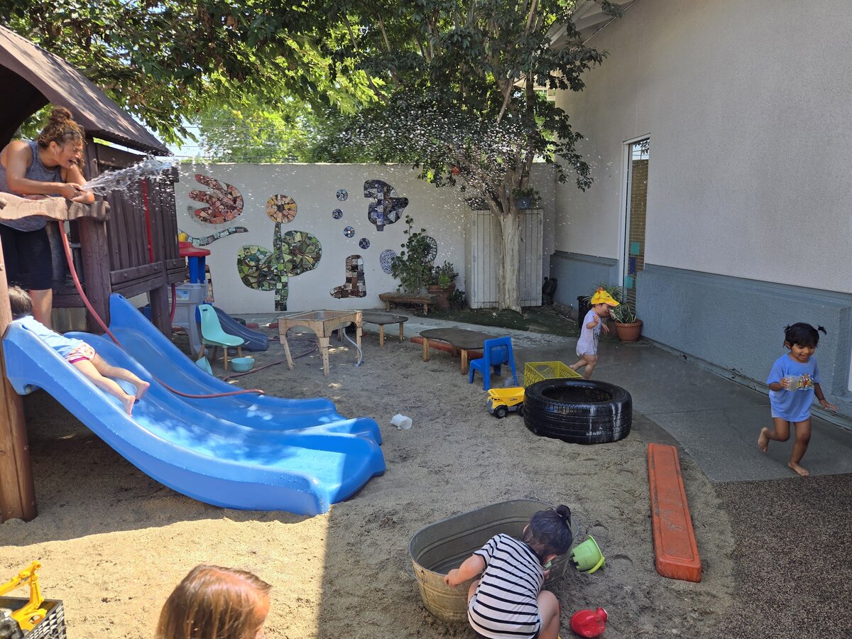 Toddlers exploring and playing together in the Kitten Room outdoor yard