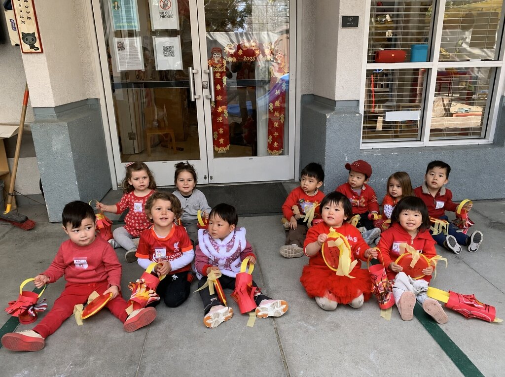 Children gathered in festive traditional attire holding handmade paper lanterns for Lunar New Year