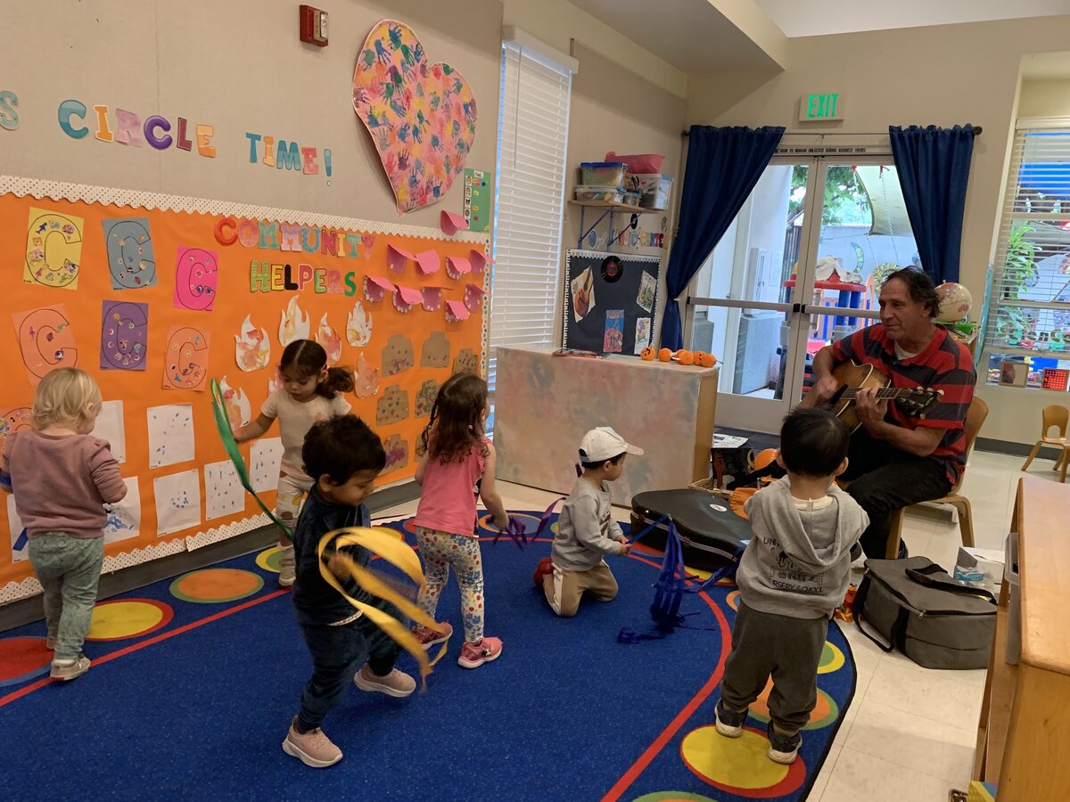 Children singing and dancing with ribbons during weekly music class