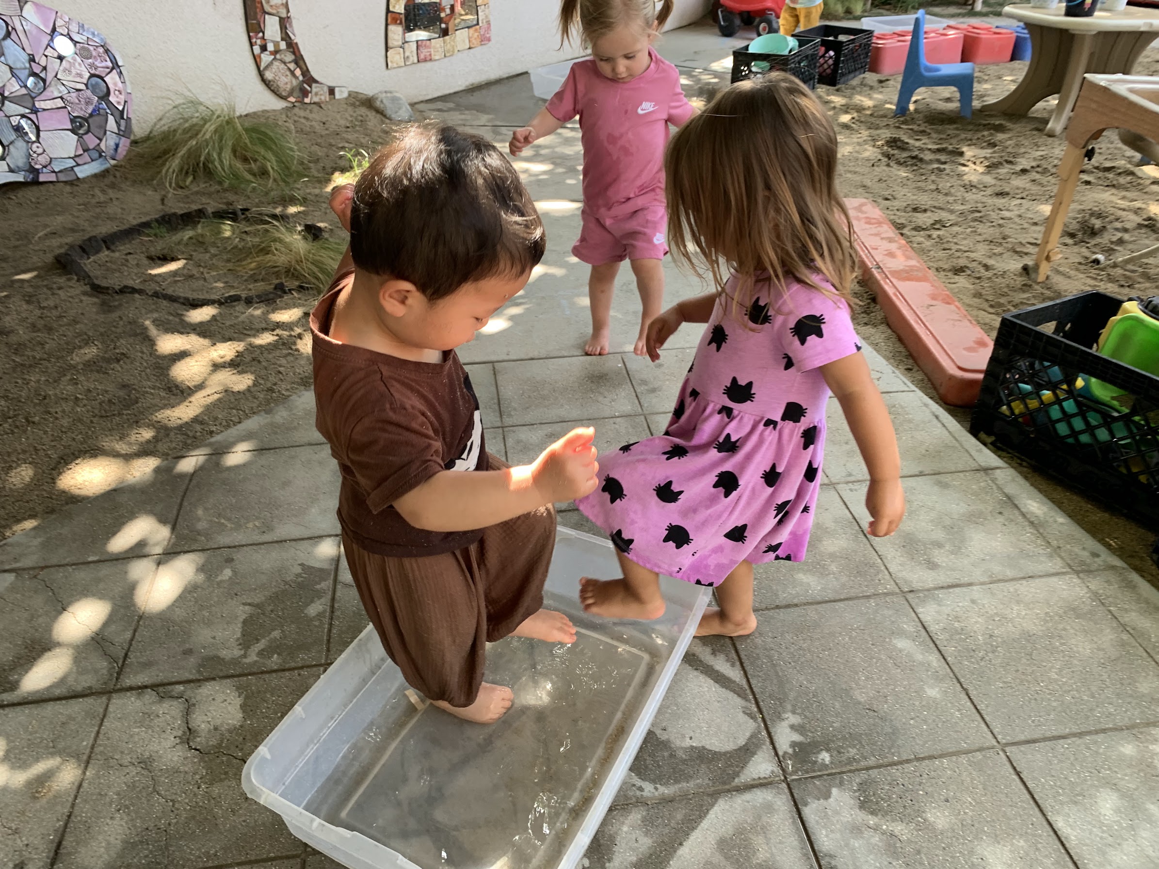 Candid photograph of children engaged in joyful outdoor play on the sunny UPNS playground